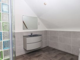 A bathroom with a wall-mounted sink cabinet mirror and glass block shower wall at Flat 3 Channel View in Torquay