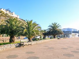 A walkway with benches and palm trees near the Princess Theatre at Flat 3 Channel View in Torquay