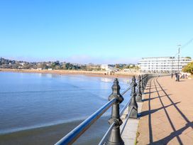 A waterfront promenade with metal railings and a building in the distance at Flat 3 Channel View in Torquay