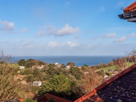 A landscape view of trees houses and the sea under a blue sky at Flat 3 Channel View in Torquay