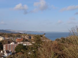 A coastal view with residential buildings trees cliffs and the sea at Flat 3 Channel View in Torquay