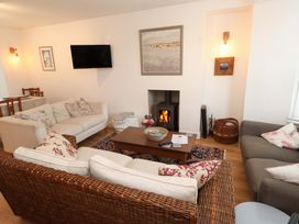 A living room with sofas, coffee table and a fireplace at Bodefi in Nefyn