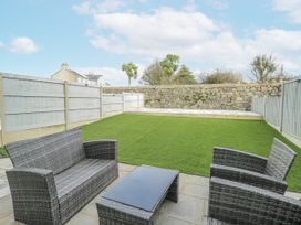 A garden with a seating area and lawn at Y Ty Pren in Brynteg near Benllech