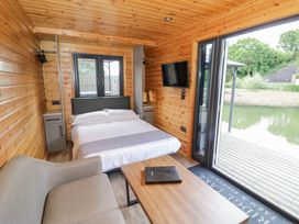 A bedroom with a bed and a sofa at Oak Lodge At Bridge Lake Farm & Fishery, Chacombe