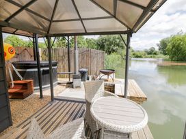 An outdoor area with a hot tub and seating at Oak Lodge At Bridge Lake Farm & Fishery Chacombe
