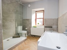 A bathroom with a shower, toilet, and bathtub at Beckside Farm in Bootle near Millom, Cumbria