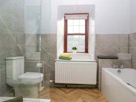 A bathroom with a toilet, shower, bathtub and window at Beckside Farm Bootle near Millom, Cumbria