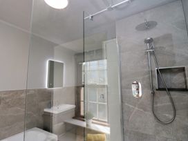 A bathroom with a shower, sink, and window at Beckside Farm Bootle near Millom Cumbria