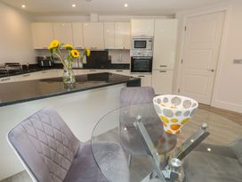 A kitchen with a table and chairs and sunflowers at Peninsula Apartment 2 St Ives