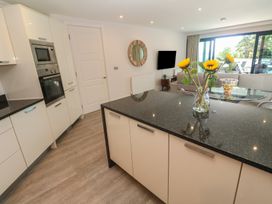 A kitchen with cabinets and a dining area at Peninsula Apartment 2 St Ives