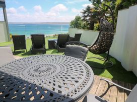 An outdoor area with a table and chairs overlooking the sea at Peninsula Apartment 2 St Ives