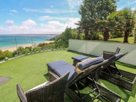 An outdoor patio with deck chairs and a view of the sea at Peninsula Apartment 2 St Ives