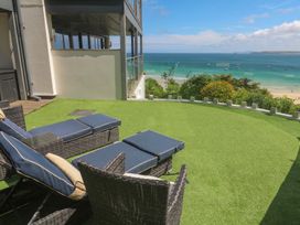 An outdoor area with chairs and an ocean view at Peninsula Apartment 2 St Ives