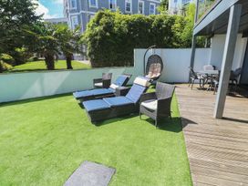 A garden with loungers and a hanging chair at Peninsula Apartment 2 in St Ives