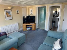 A living room with a television on a stand and a sofa at Monarch in Brewers Quay Harbour