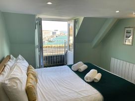 A bedroom with a bed and a view of the harbor at Monarch Brewers Quay Harbour
