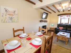 A dining room with table set for meals at Bwthyn Y Wennol in Dolwen near Abergele