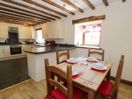 A kitchen with a dining table and chairs at Bwthyn Y Wennol Dolwen near Abergele