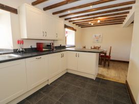 A kitchen with cabinets and appliances at Bwthyn Y Wennol in Dolwen near Abergele