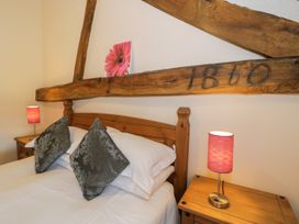 A bedroom with a bed and bedside tables at Bwthyn Y Wennol Dolwen near Abergele