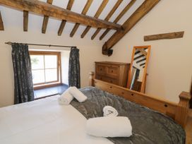 A bedroom with a bed and window at Bwthyn Y Wennol in Dolwen near Abergele