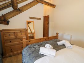 A bedroom with a bed and dresser at Bwthyn Y Wennol Dolwen near Abergele