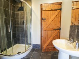 A bathroom with a shower enclosure and sink at Bwthyn Y Wennol Dolwen near Abergele