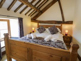 A bedroom with a wooden bed and bedside table at Bwthyn Y Wennol Dolwen near Abergele