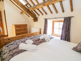 A bedroom with a bed and dresser at Bwthyn Y Wennol Dolwen near Abergele