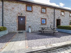 An outdoor area with a stone wall and picnic table at Bwthyn Y Wennol Dolwen near Abergele