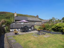 A garden with a patio table and chairs at Arthur’s Cottage Abergynolwyn near Tywyn