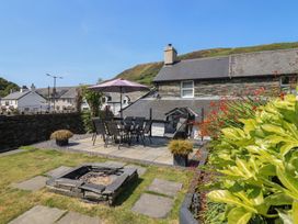 A garden with a dining set and fire pit at Arthur’s Cottage Abergynolwyn near Tywyn