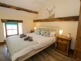 A bedroom with a bed and bedside table at Cornel Clyd, Dolwen near Abergele