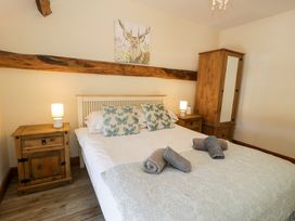 A bedroom with a bed, nightstand, and wardrobe at Cornel Clyd, Dolwen near Abergele
