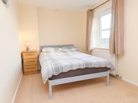 A bedroom with a bed and nightstand at Pant Fali in Aberdaron