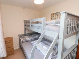 A bedroom with a bunk bed and nightstand at Pant Fali in Aberdaron