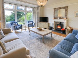 A living room with a fireplace and two armchairs at Fern Bank in Penrith