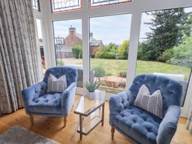 A conservatory with chairs and table at Fern Bank in Penrith