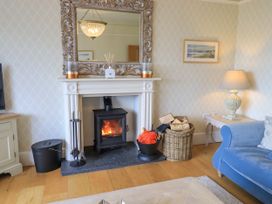 A living room with a fireplace and mirror at Fern Bank in Penrith