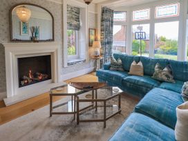A living room with a fireplace and a sofa at Fern Bank in Penrith