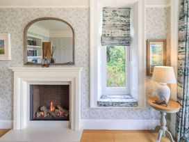 A living room with fireplace and window seat at Fern Bank in Penrith