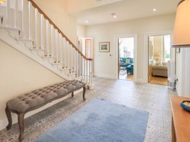 A hallway with a staircase and a bench at Fern Bank in Penrith