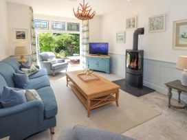 A living room with a fireplace and television at Fern Bank in Penrith