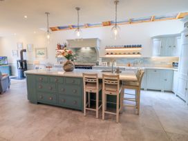 A kitchen with a central island and stools at Fern Bank in Penrith