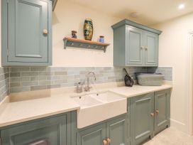 A laundry room with cupboards and a sink at Fern Bank in Penrith