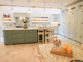 A kitchen with a modern design featuring an island and bar stools at Fern Bank Penrith