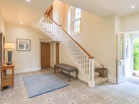 A hallway with a staircase and bench at Fern Bank in Penrith