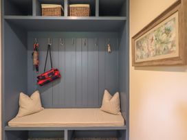 A mudroom with bench, cushion, hooks and baskets at Fern Bank in Penrith