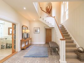 A hallway with a staircase and console table at Fern Bank in Penrith