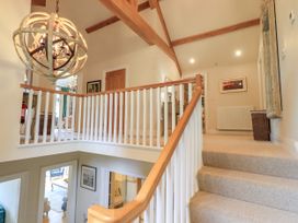 A hallway with staircase and a chandelier at Fern Bank in Penrith